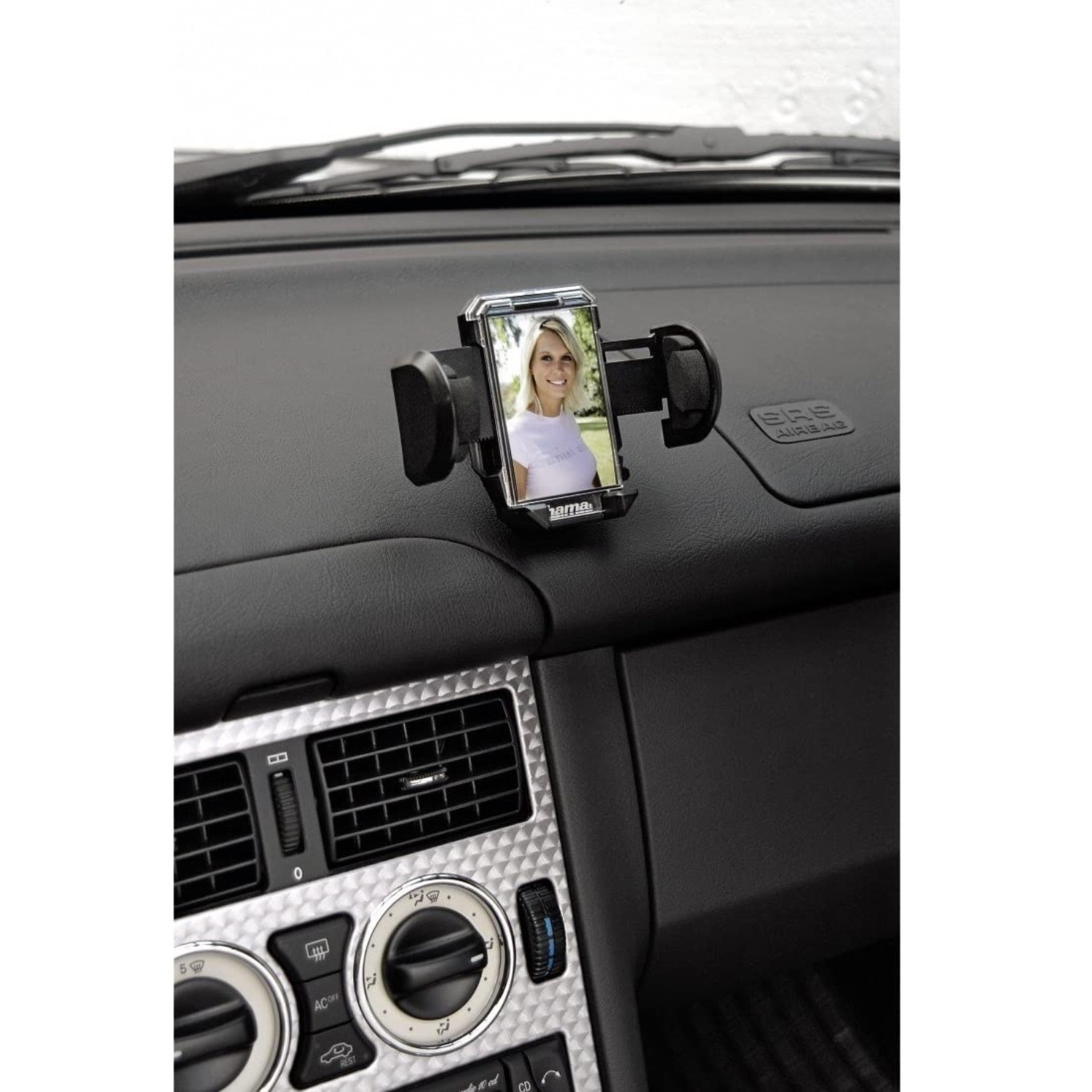 Ein Handyhalter mit einem Foto einer Frau auf dem Armaturenbrett eines Autos.