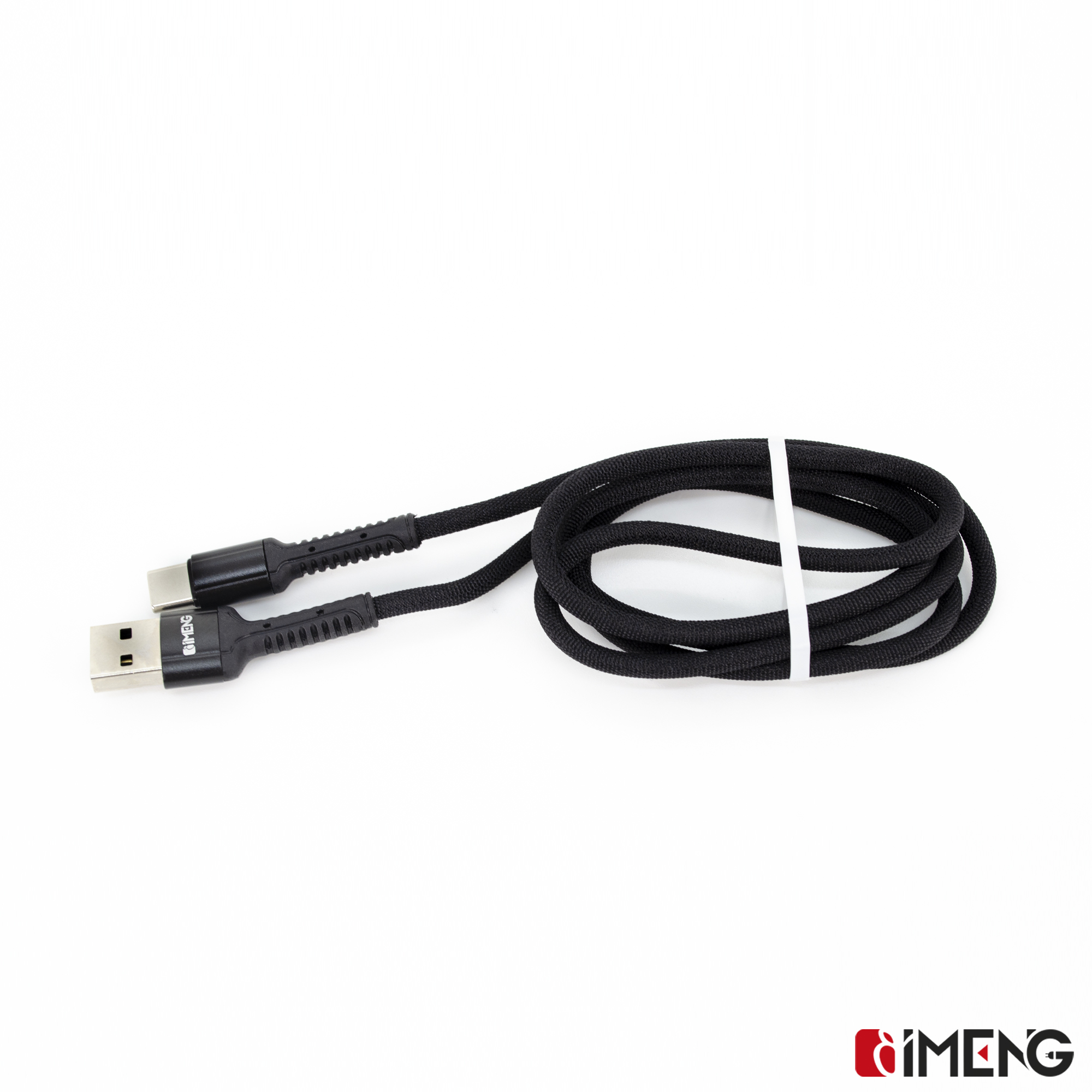 Siyah, kumaş kaplı USB-C - USB-A kablosu, rulo yapılmış ve beyaz bir bantla sabitlenmiş.