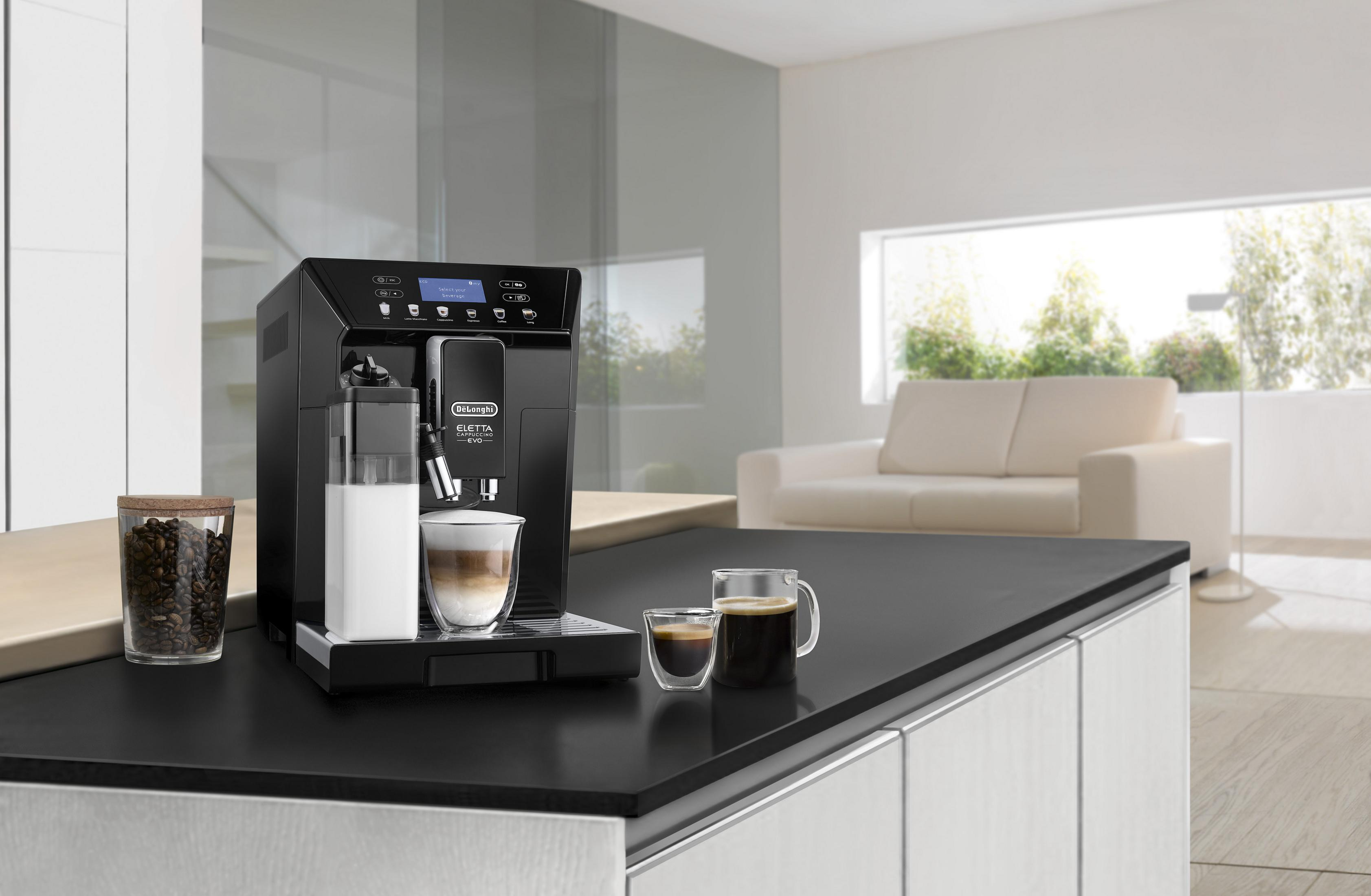 Une machine à café noire avec carafe à lait, tasses à café et grains de café.