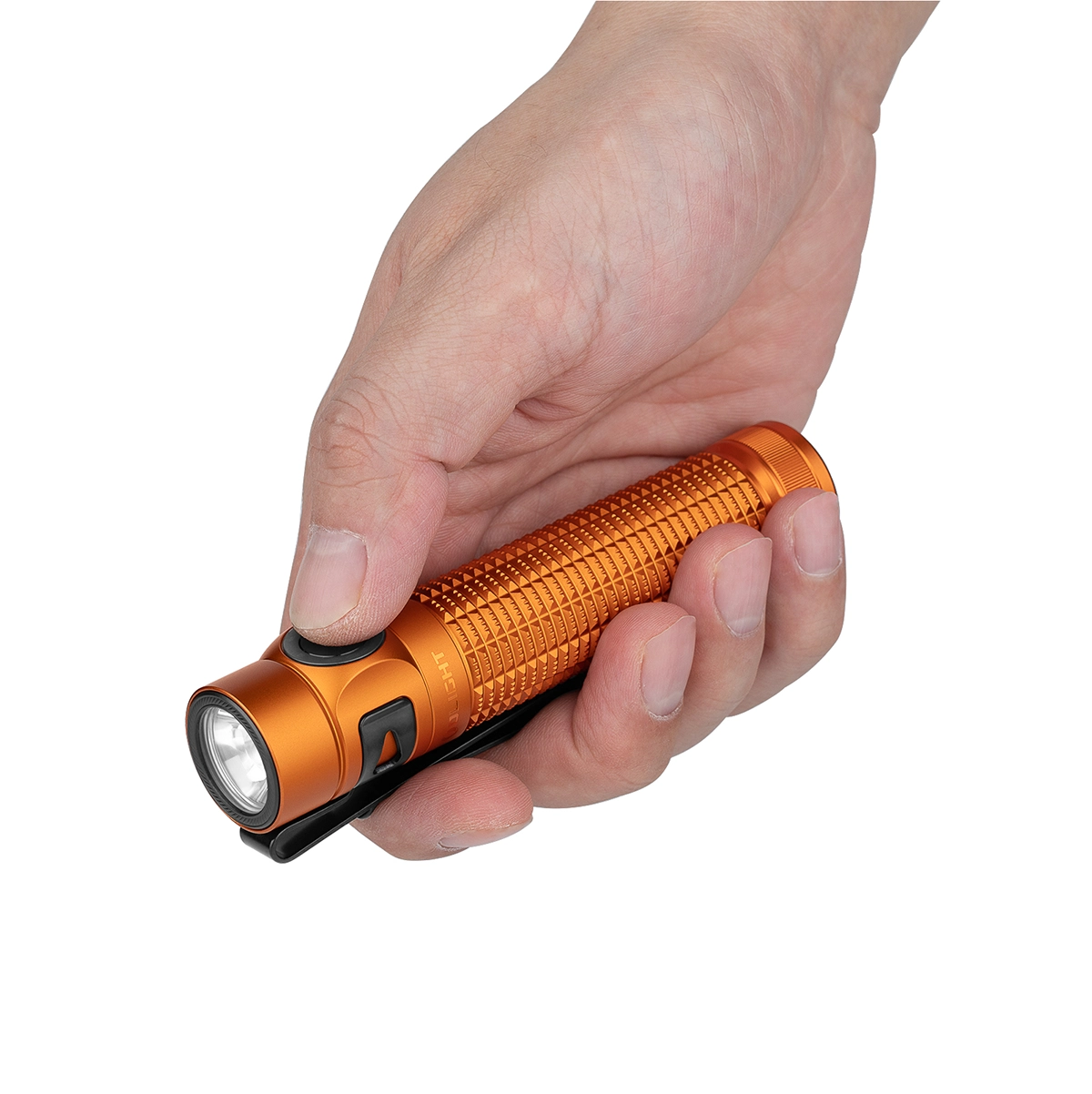 Una mano sostiene una linterna pequeña y naranja con patrón de diamantes.