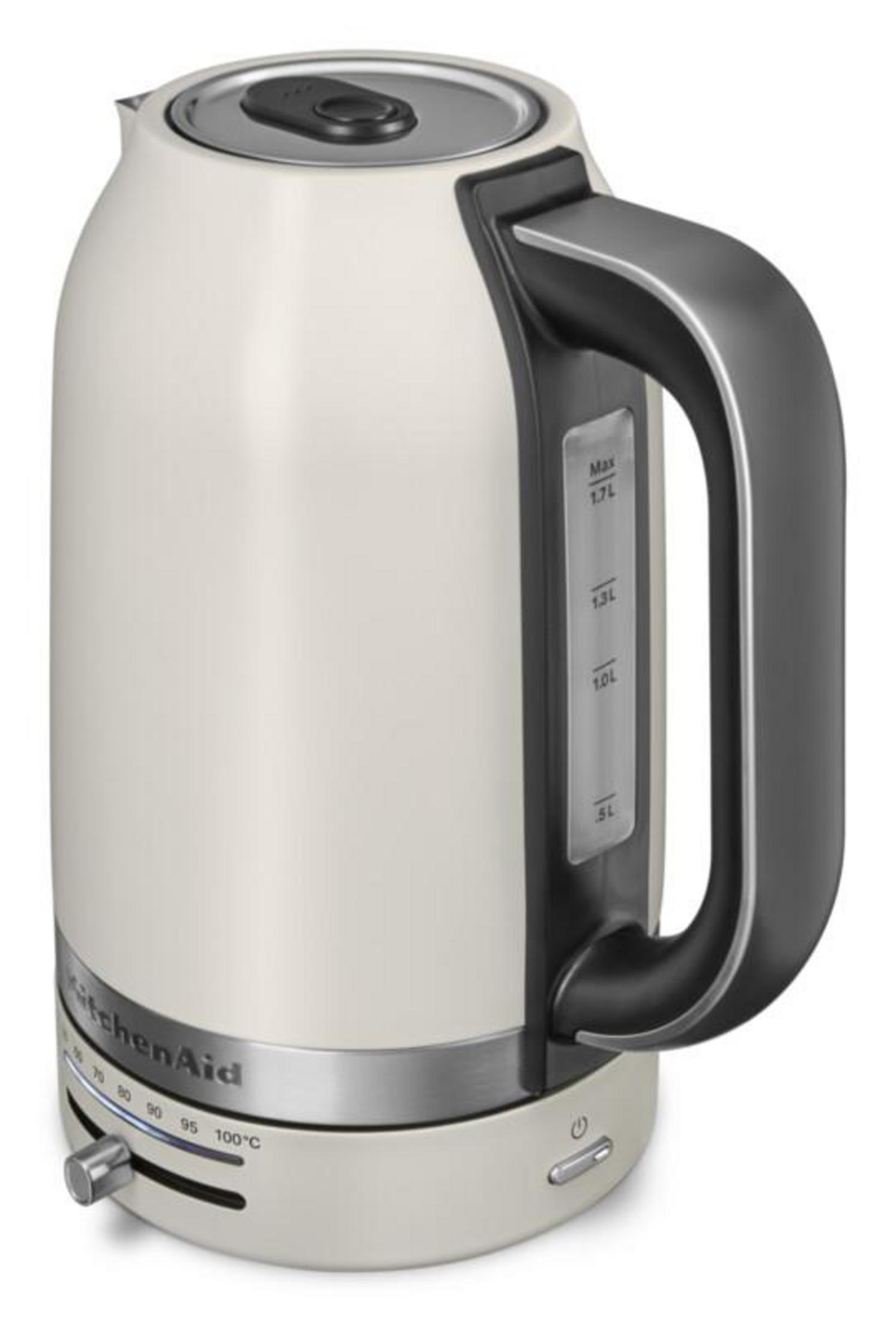 Kremowy czajnik elektryczny KitchenAid z czarną rączką i regulacją temperatury.