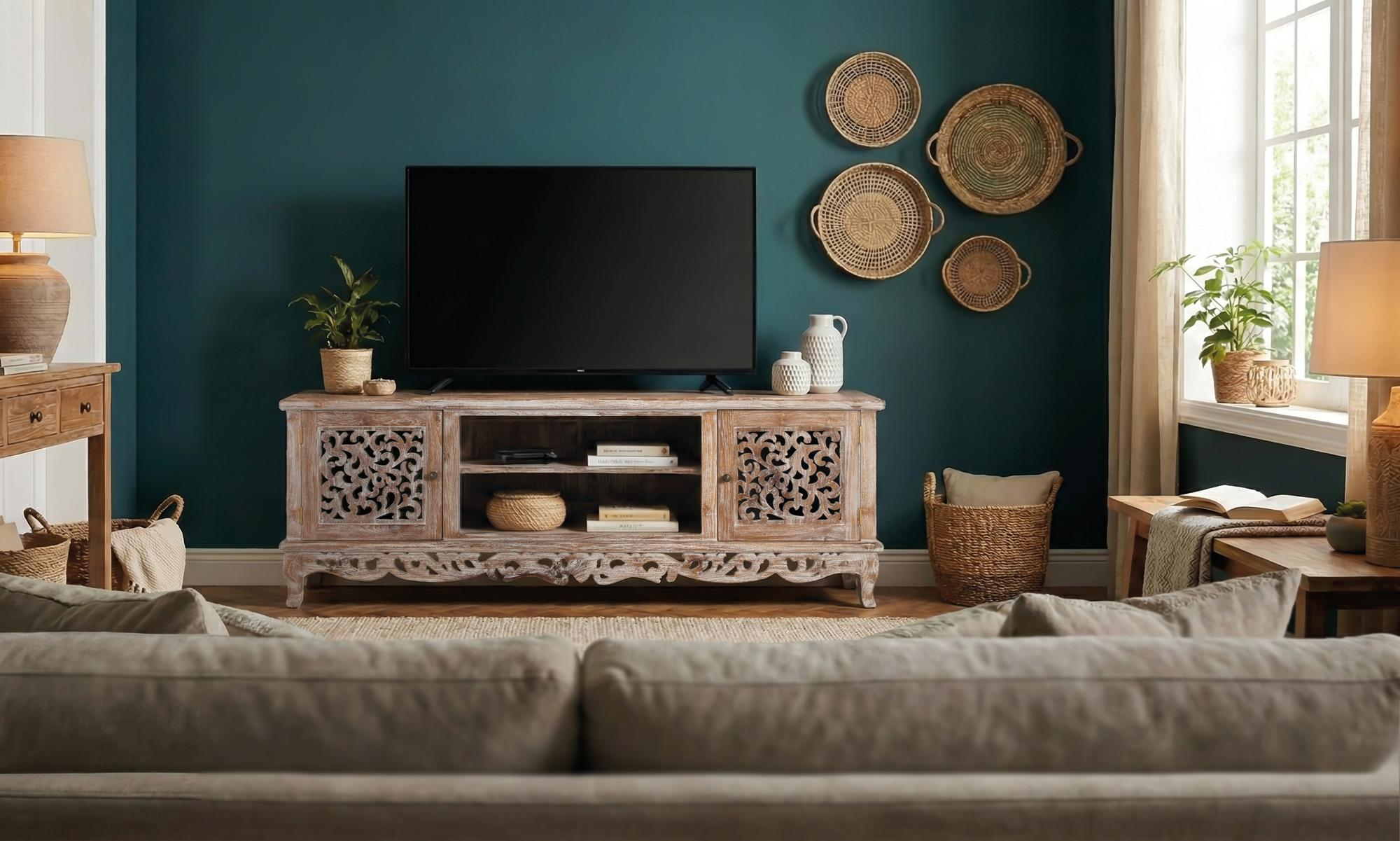 Una sala de estar con paredes verde azulado, TV sobre un mueble y decoración tejida.