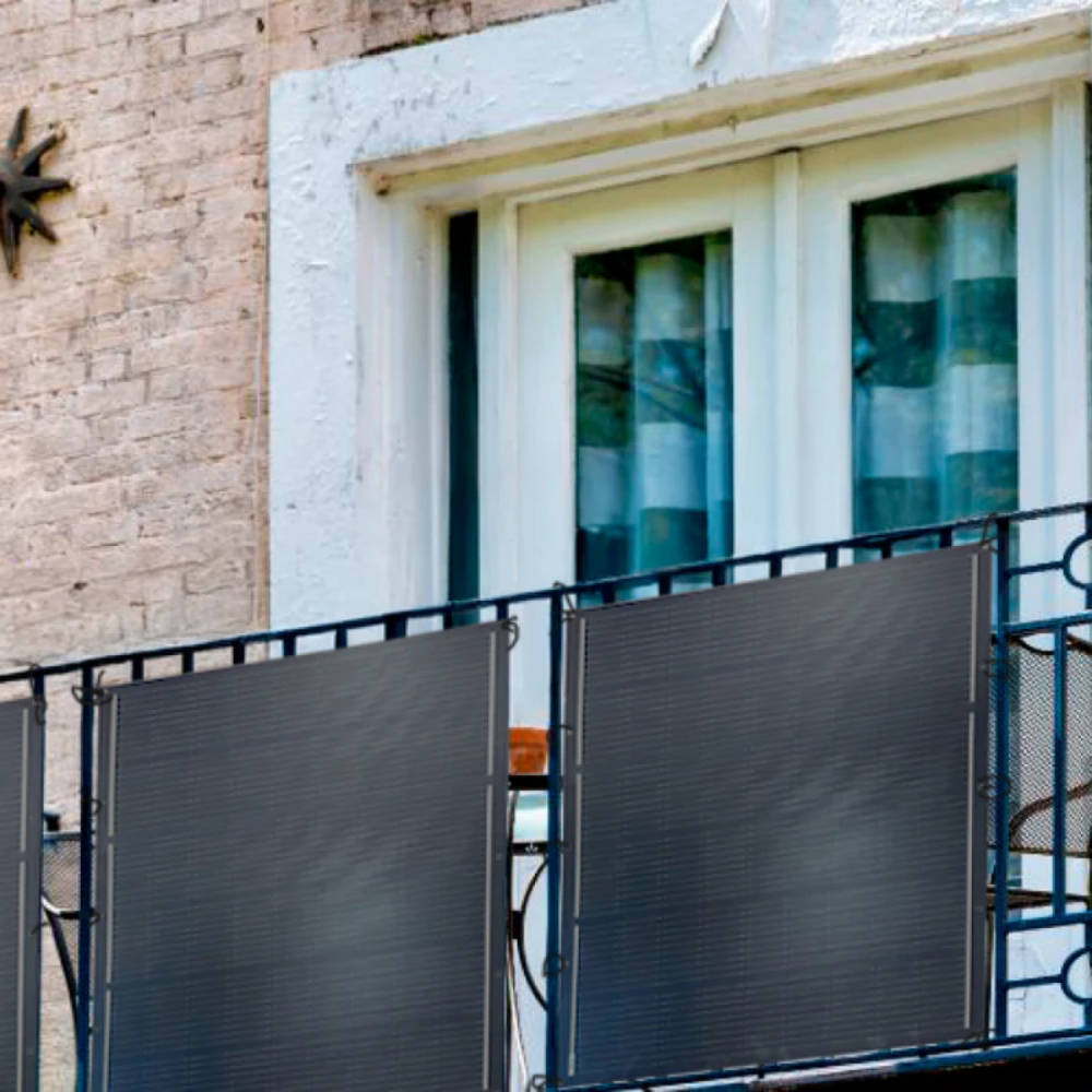 Pantas de privacidad para balcón gris oscuro unidas a barandillas, con pared de ladrillos y ventana detrás.