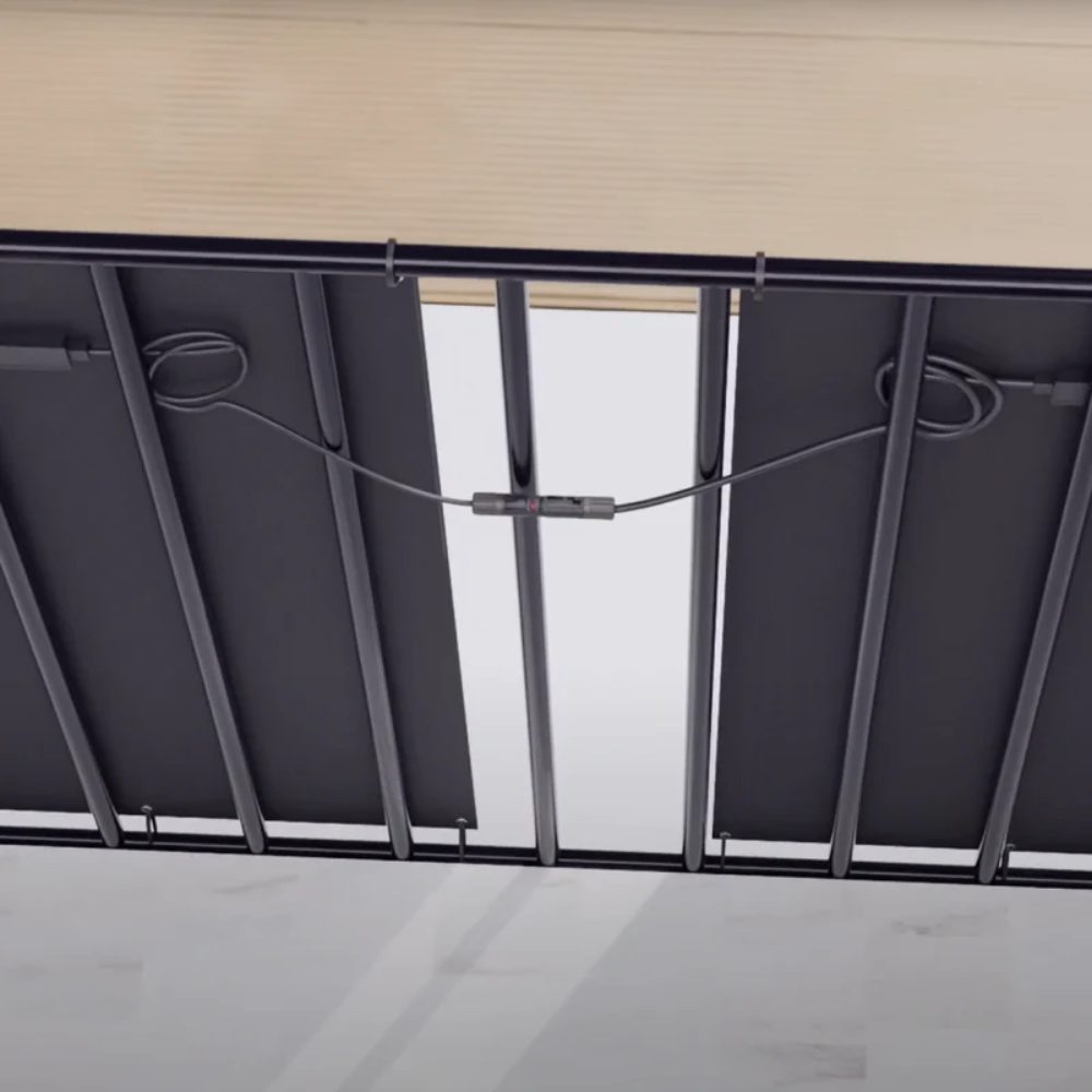 Parte inferior de paneles solares conectados por cables y una caja de empalmes.