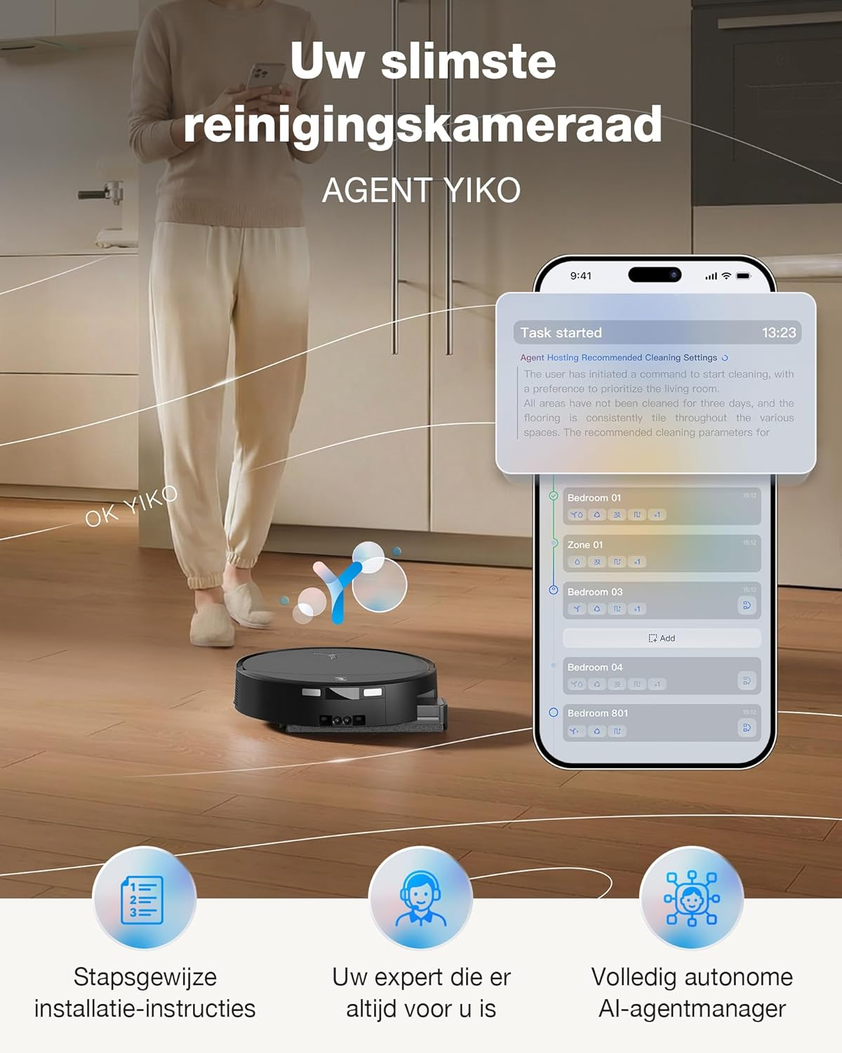 Un robot aspirateur nettoie un parquet tandis qu'une personne se tient à proximité. Un smartphone affiche l'application.