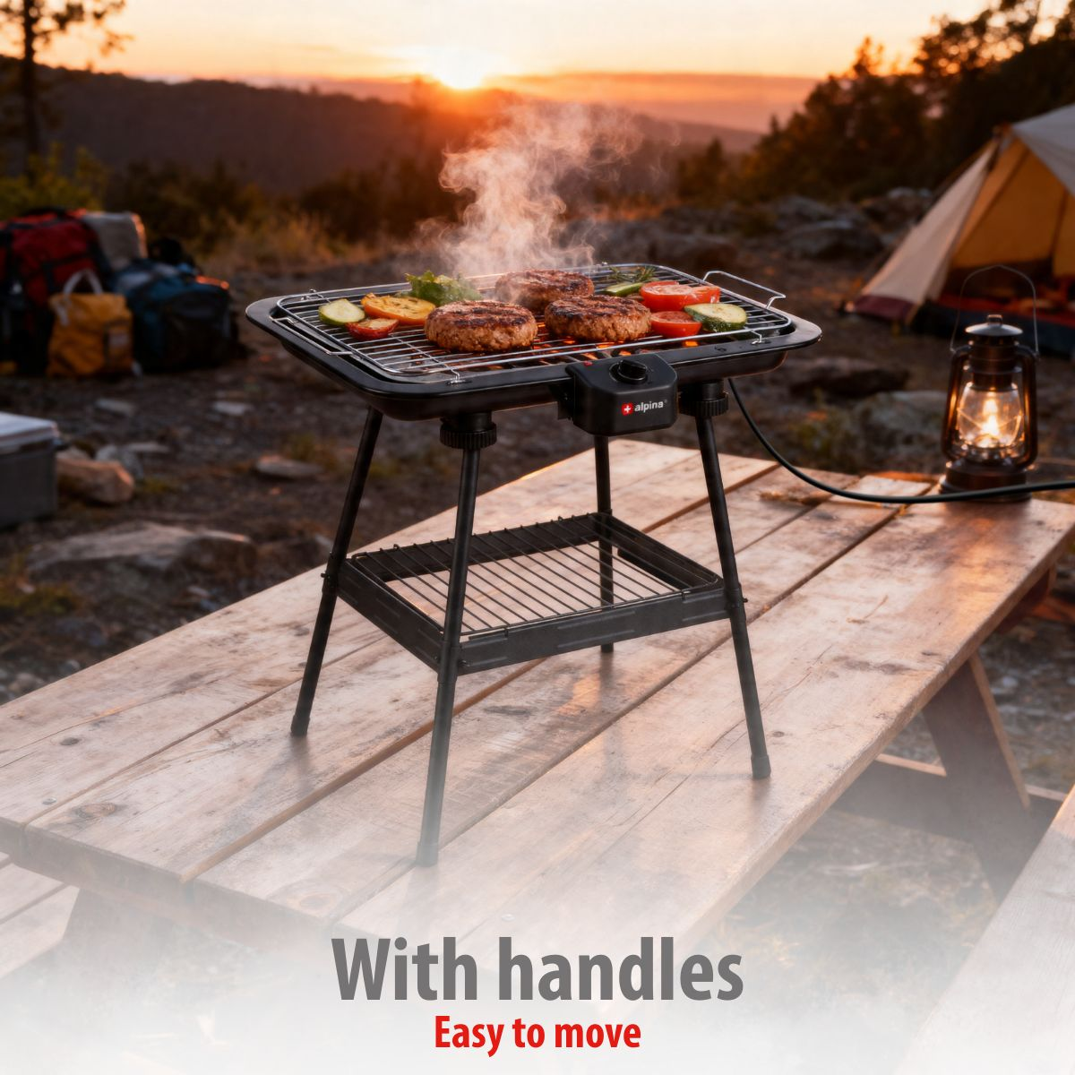 An electric grill with burgers and vegetables on a picnic table at sunset.