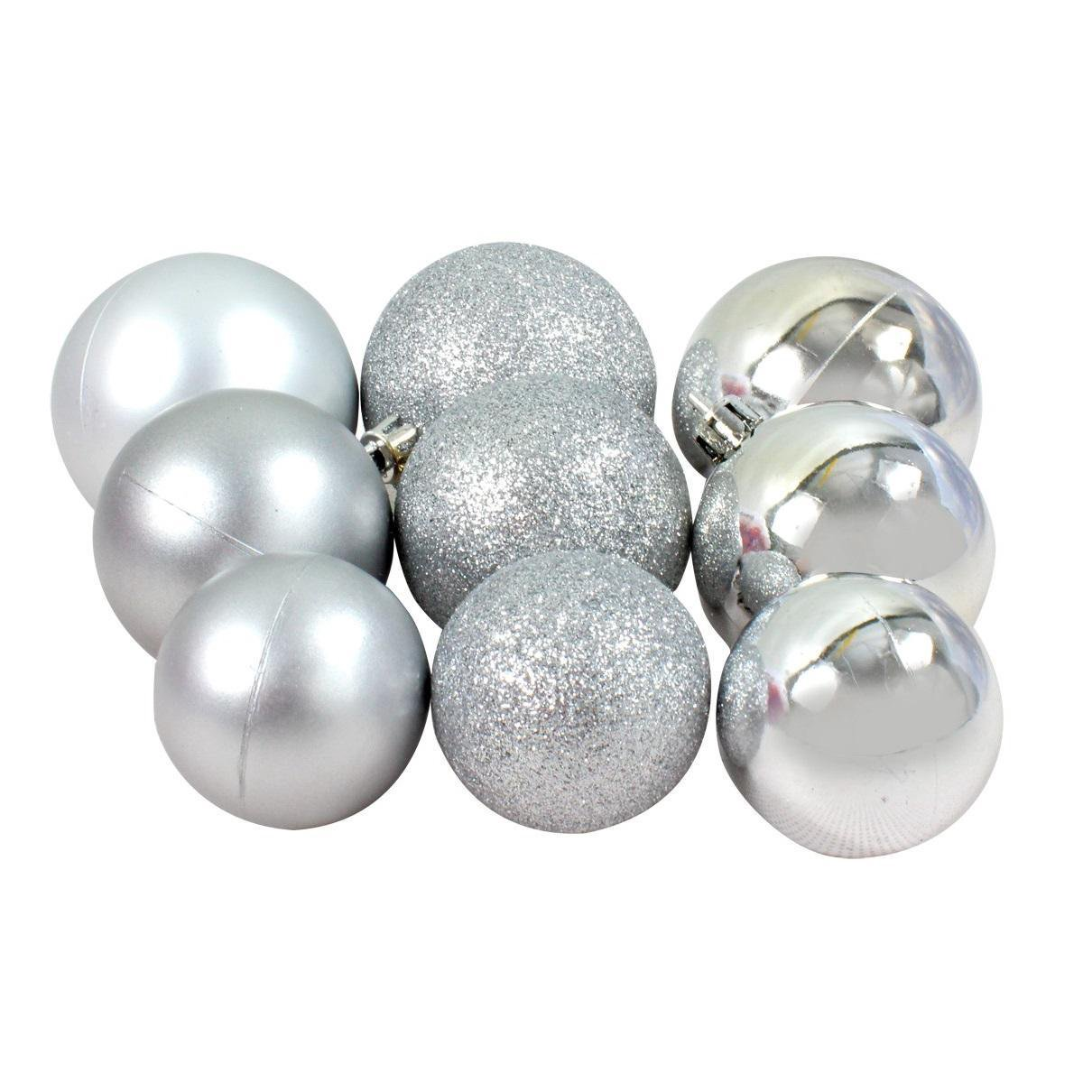 Een groep zilveren kerstballen, sommige glinsterend, andere glanzend, op witte achtergrond.