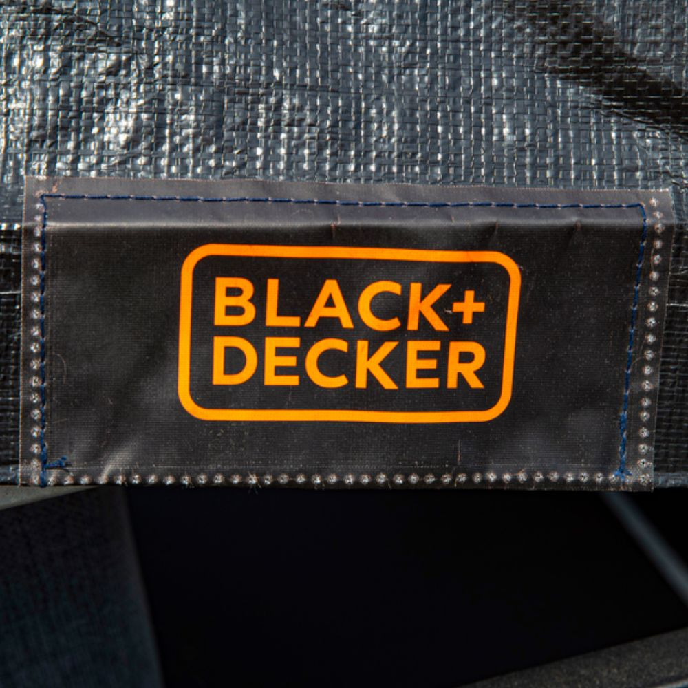 Een zwart label met het oranje BLACK+DECKER logo op een grijs, getextureerd oppervlak.