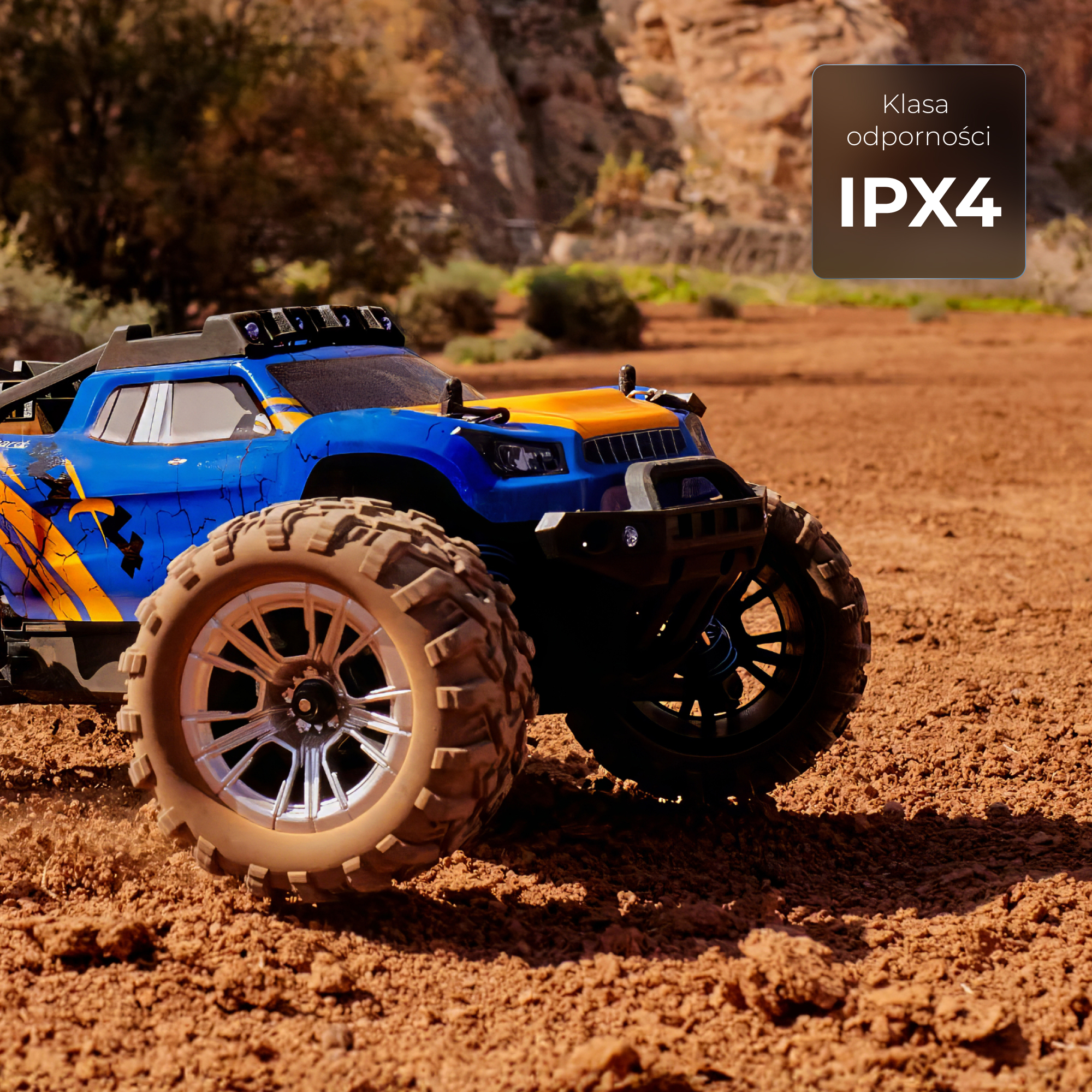 Ein blau-gelber ferngesteuerter Monstertruck fährt über unebenes Gelände.