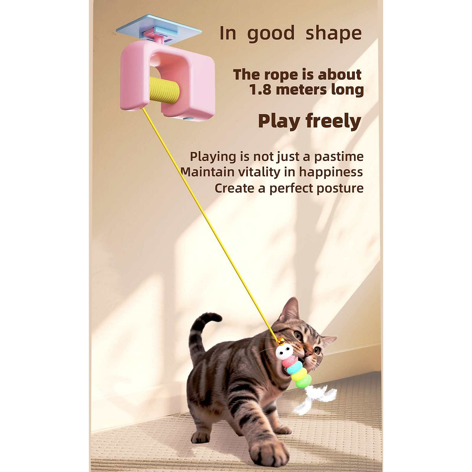 Eine Katze spielt mit einem Spielzeug an einer Schnur, die von einem rosa Gerät an der Wand herabhängt.