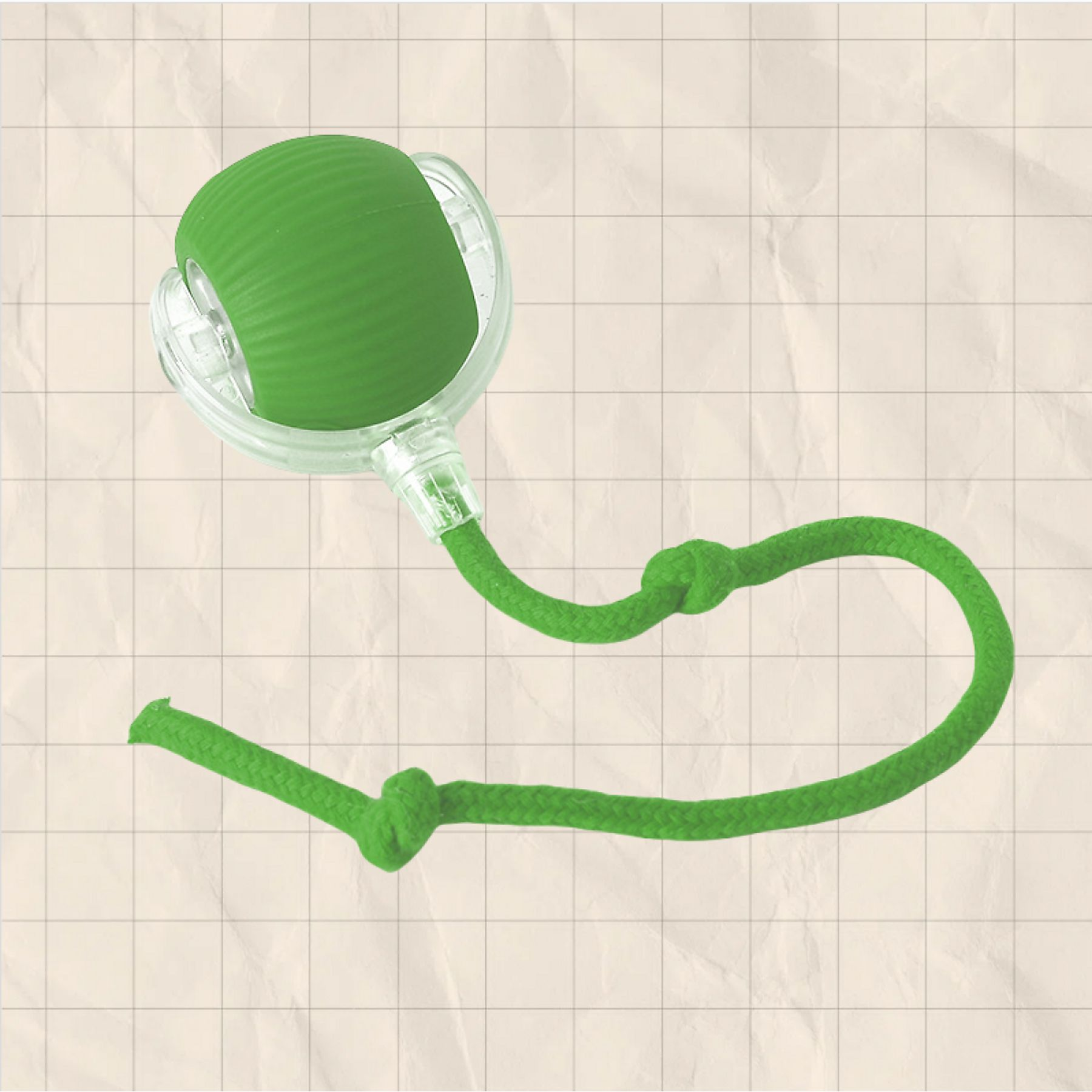 Grüner Ball mit Schnur und Knoten auf kariertem Hintergrund.