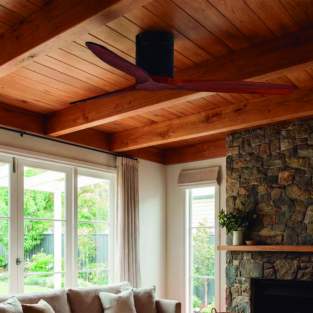 Ventilador de techo de madera con tres aspas sobre chimenea de piedra y ventanas.