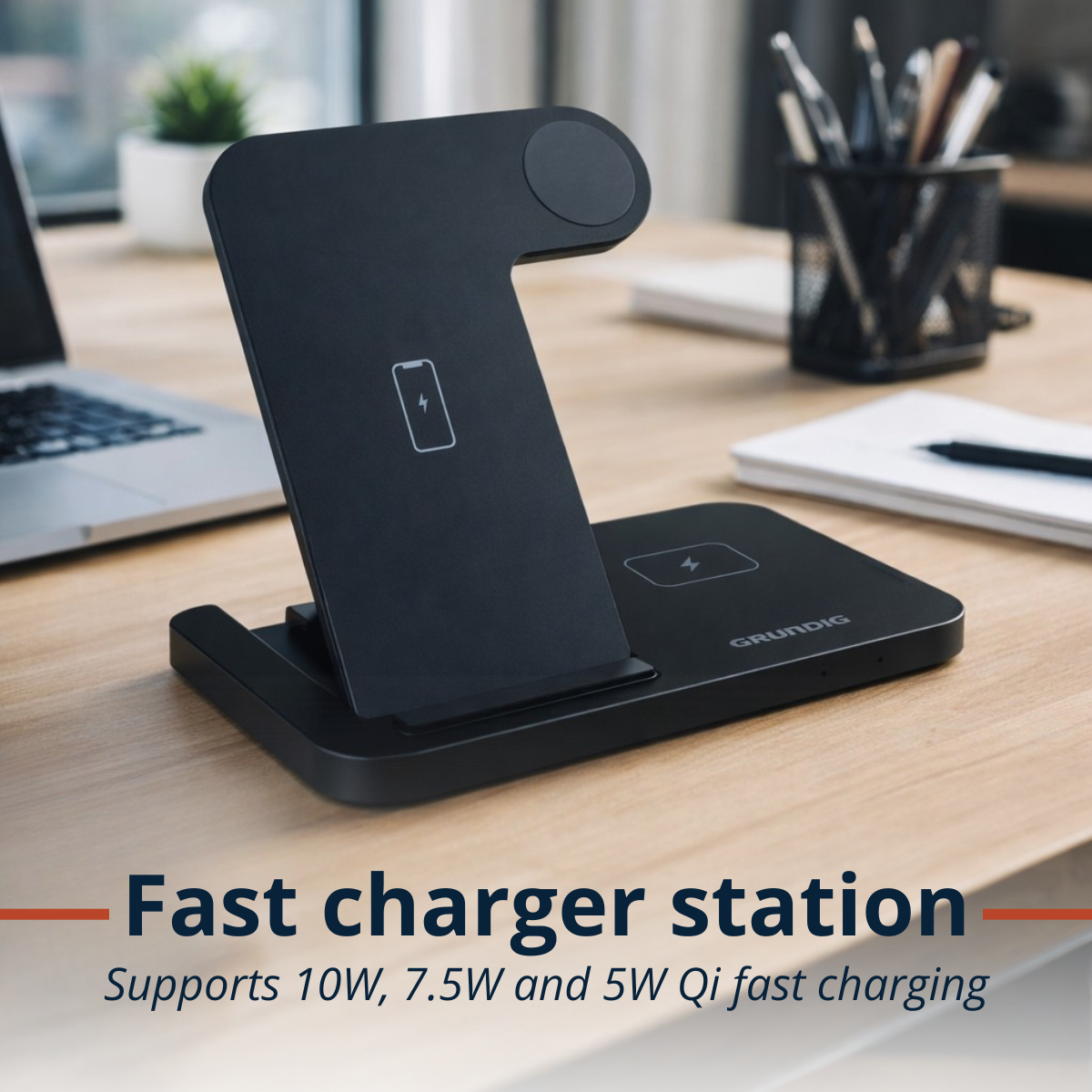 Een zwart oplaadstation voor meerdere apparaten op een houten bureau met laptop.