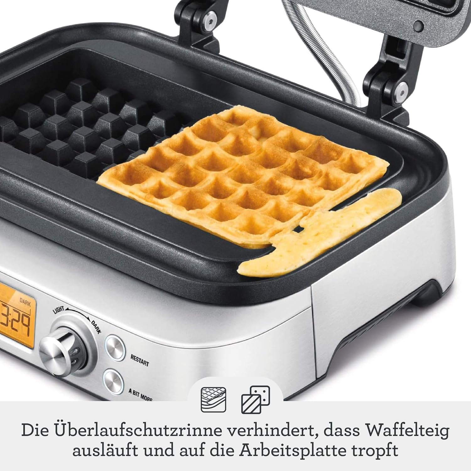 Ein goldbrauner Waffel wird in einer offenen Waffelmaschine gebacken.