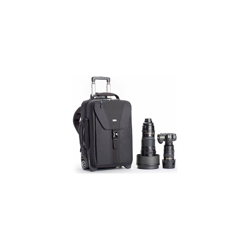 A black rolling suitcase next to two camera lenses and a camera.