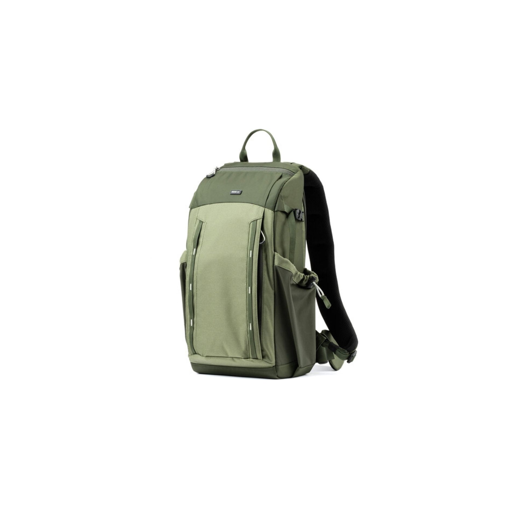 A green backpack with multiple pockets and zippers stands on a white background.