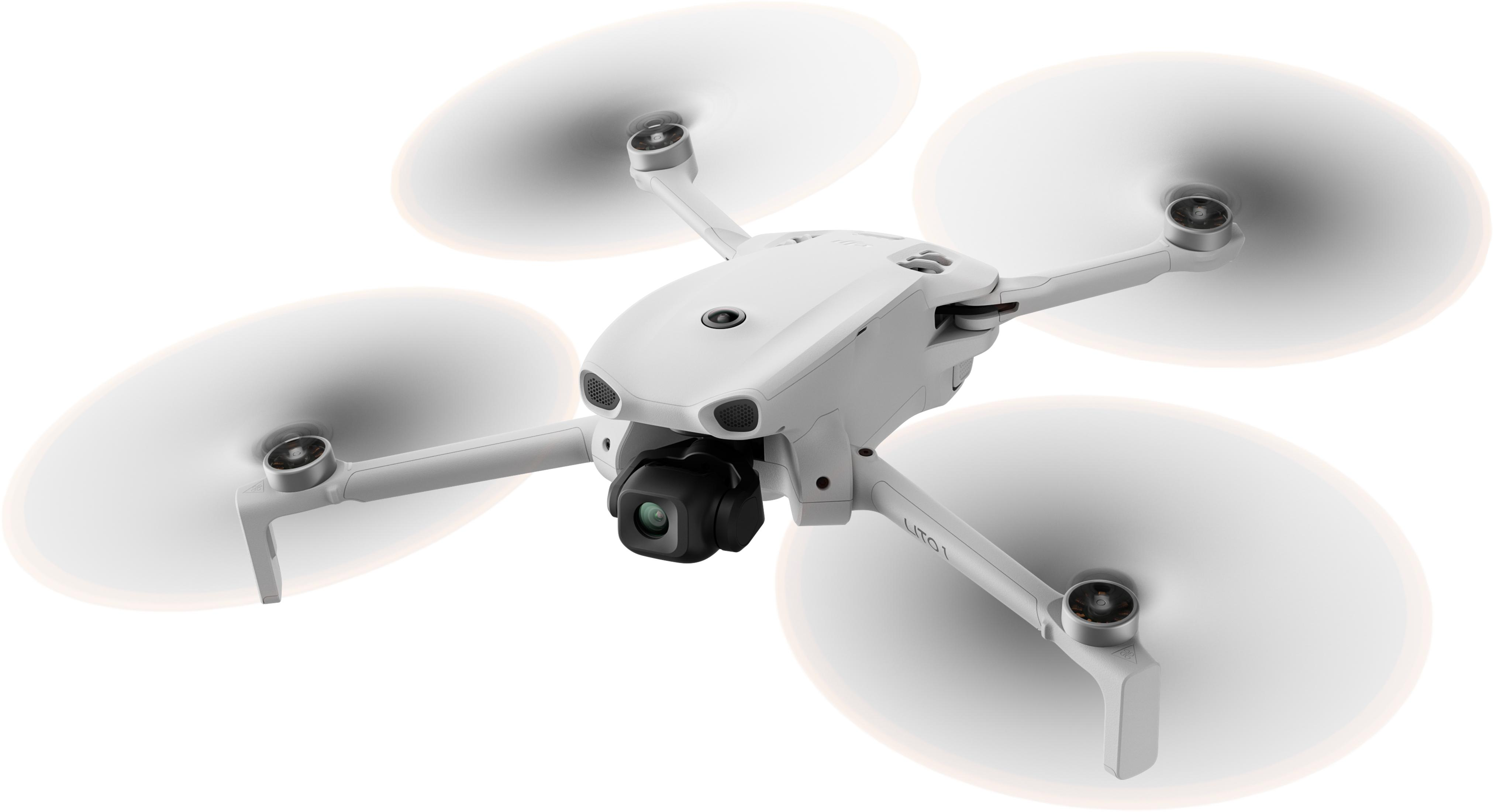 Un dron blanco con cuatro hélices y cámara vuela sobre fondo blanco.