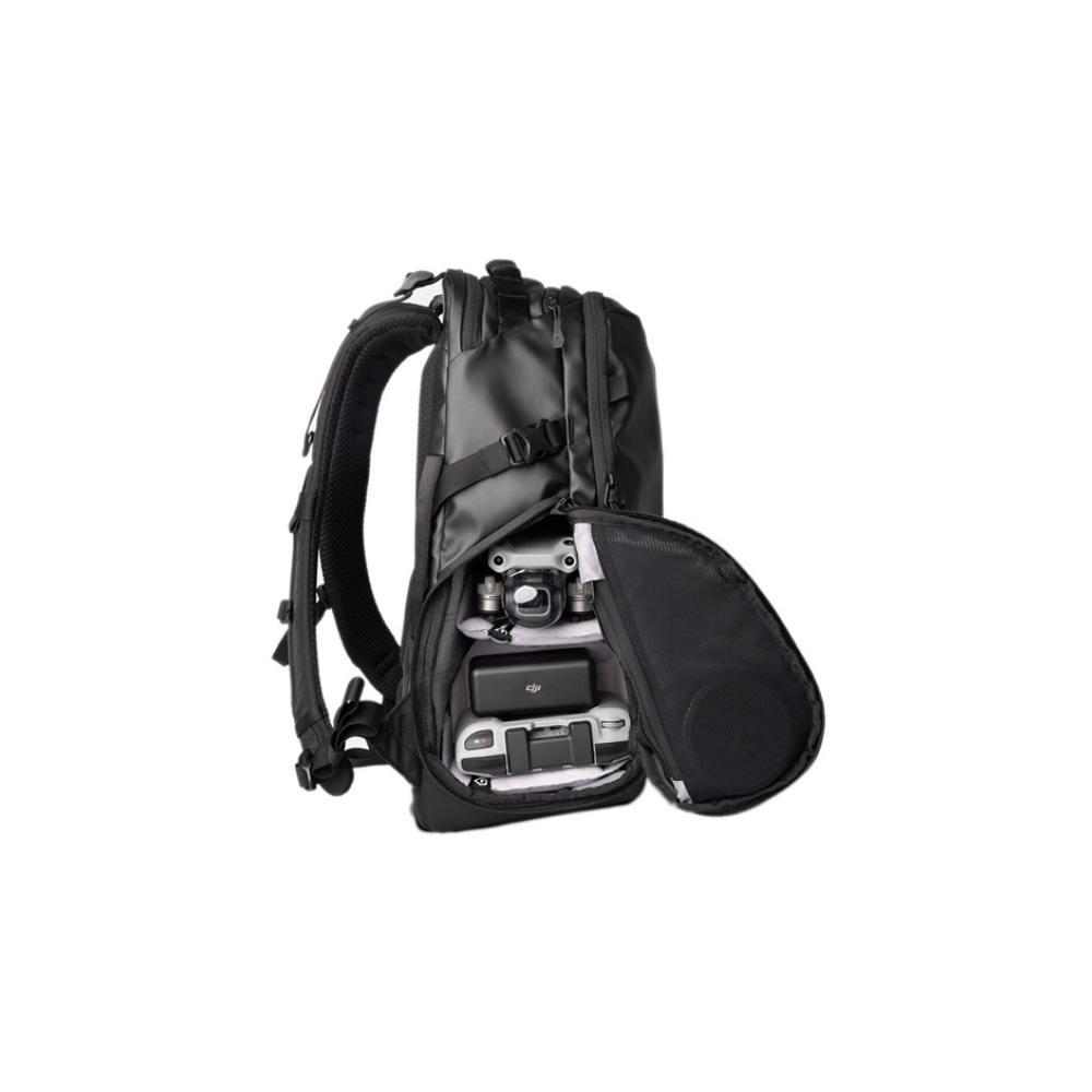 A black backpack with its front pocket open, revealing drones and accessories inside.