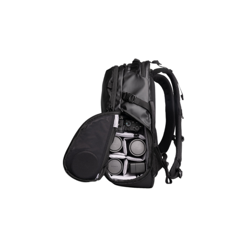 Black backpack with an open compartment revealing cameras and lenses.