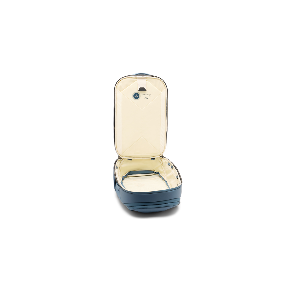 Open blue backpack with cream interior and logos on the lid.