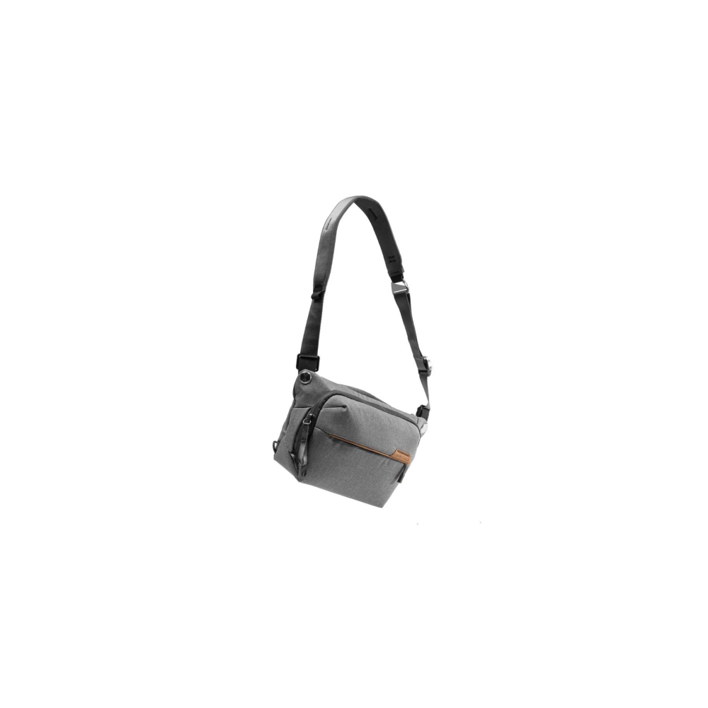 Grijze crossbody tas met bruine accenten en verstelbare band.