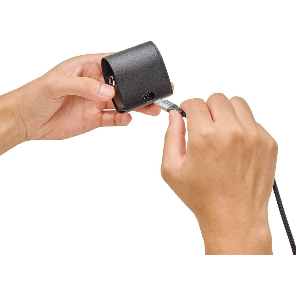 Person connects a black charging cable to a gray charging adapter case.
