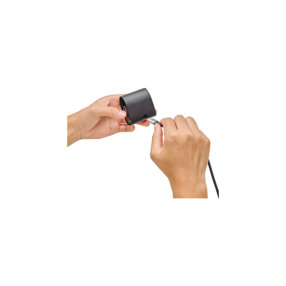 Hands plugging a black cable into a black charger.