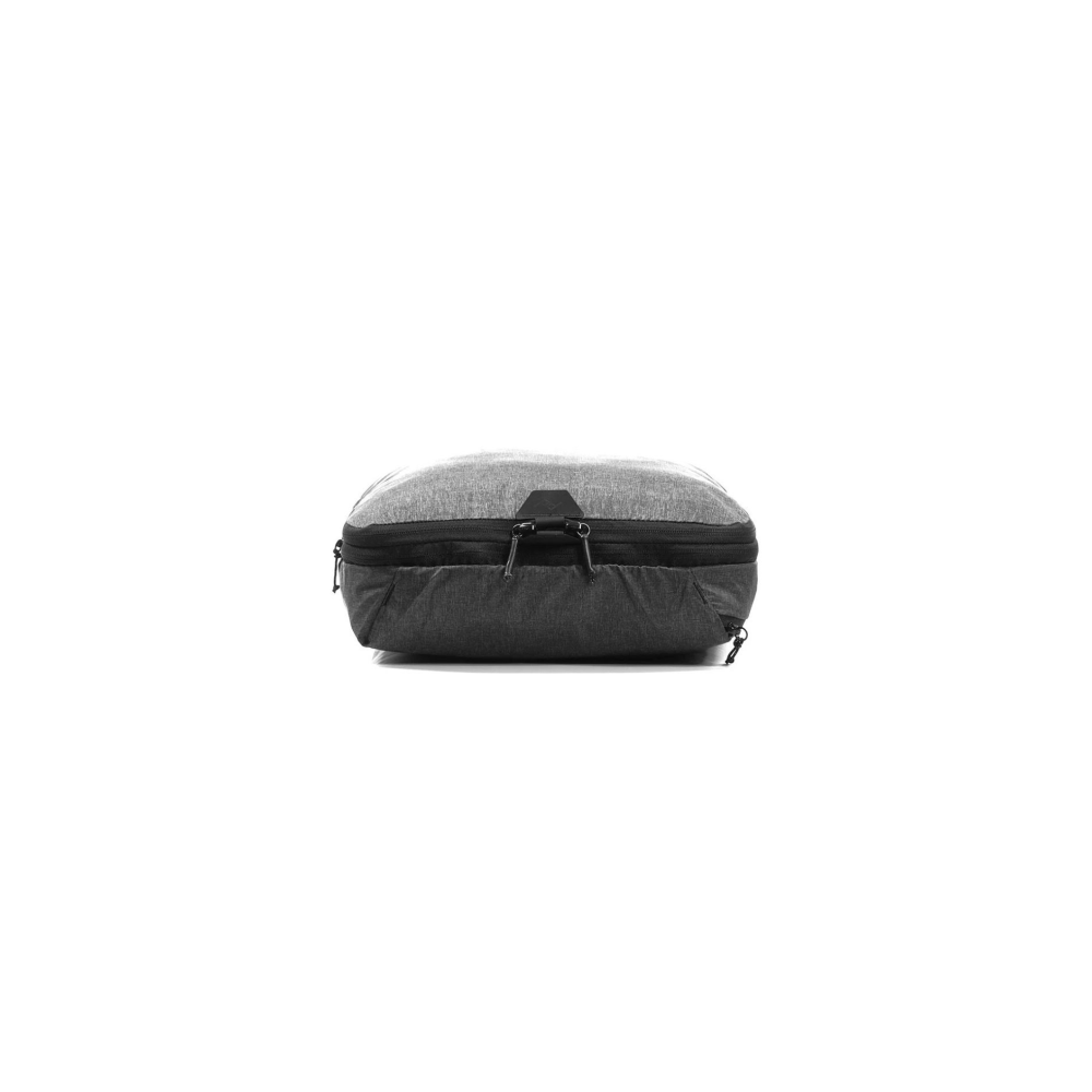 Een grijze en antracietkleurige packing cube met ritsen op een witte achtergrond.