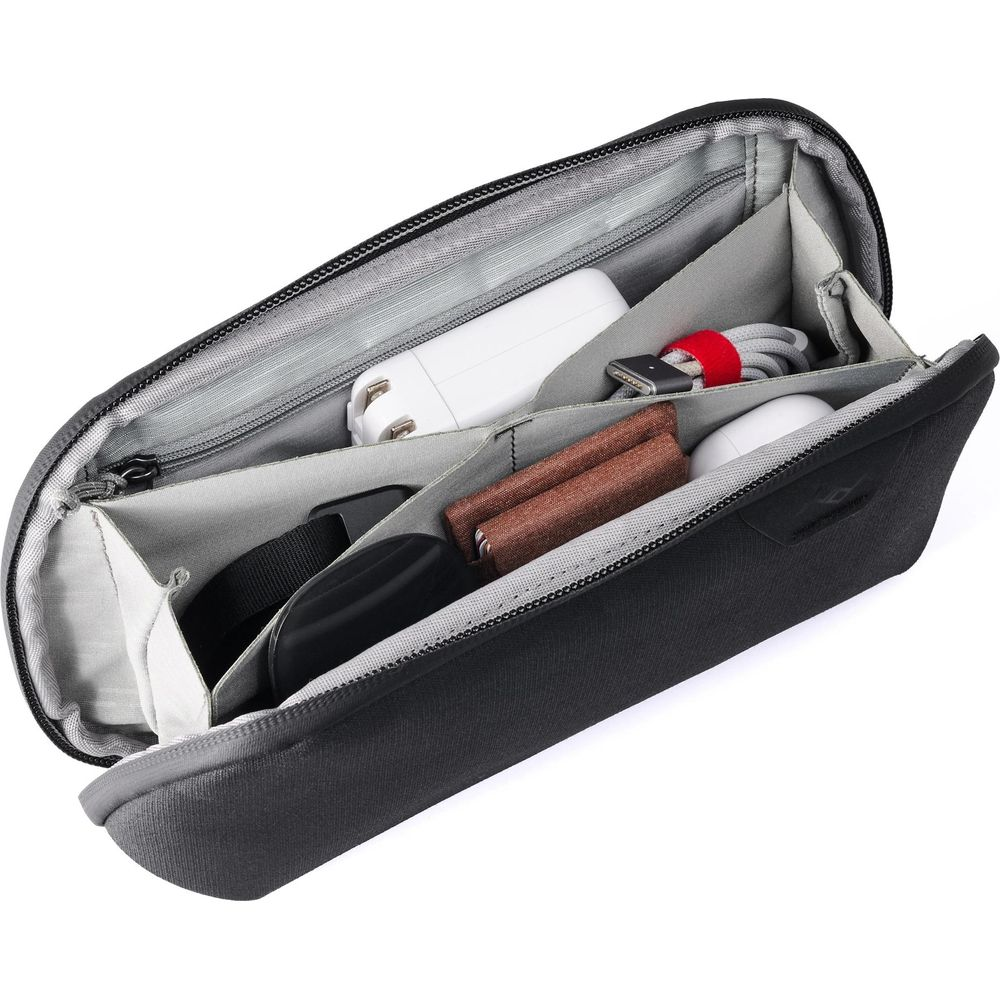 Zwarte tas met verdeeld interieur, met opladers, kabels en oordopjes.