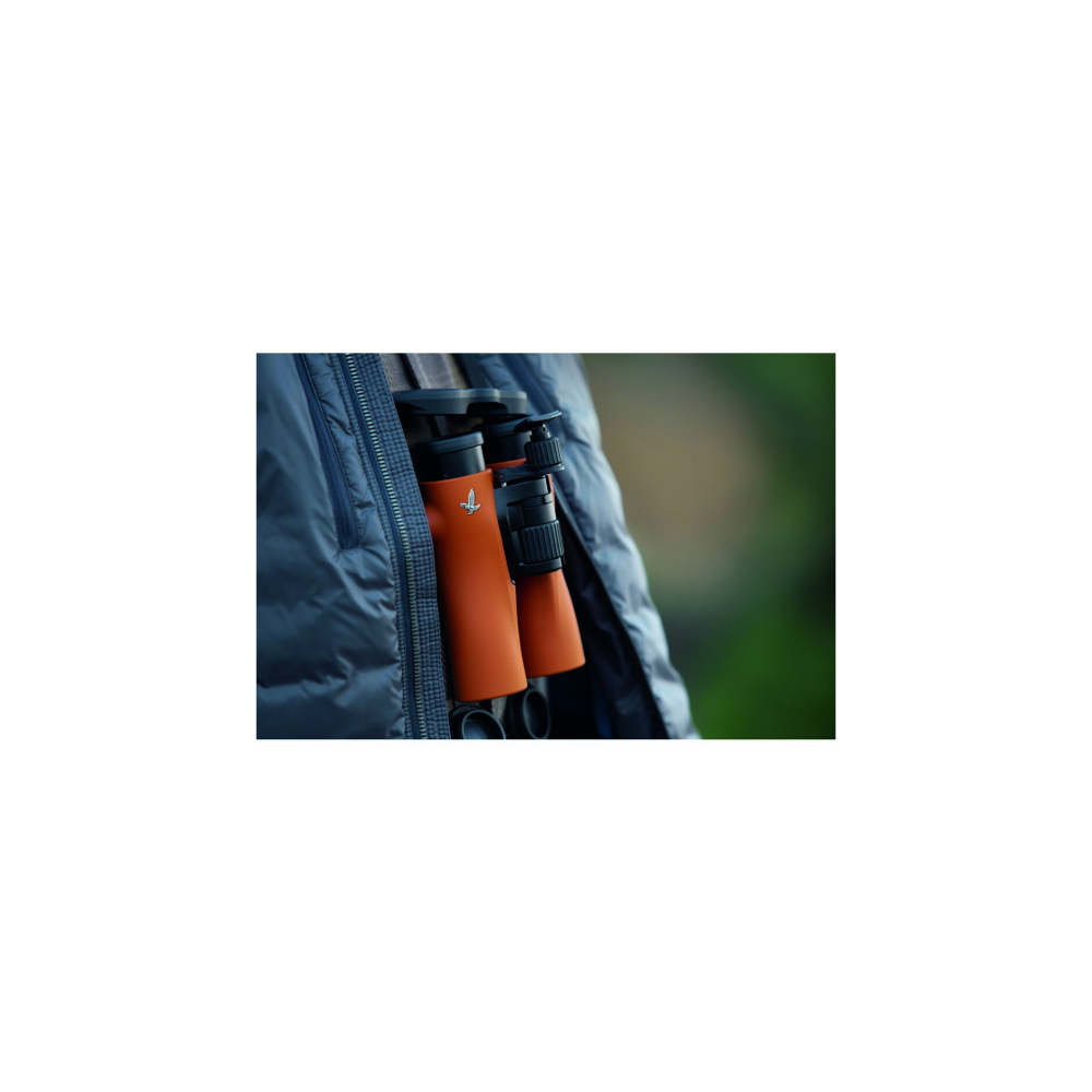 Orange binoculars with Swarovski logo in a jacket pocket, blurred background.