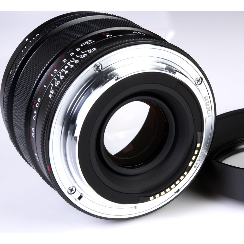 A black camera lens with silver mount is shown. Focus and aperture markings are visible.