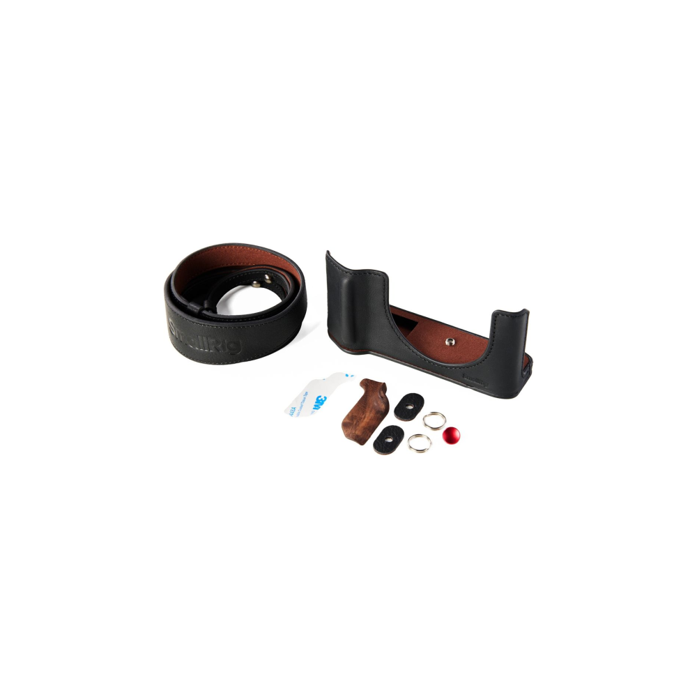 A black leather camera case, camera strap, and accessories on a white background.