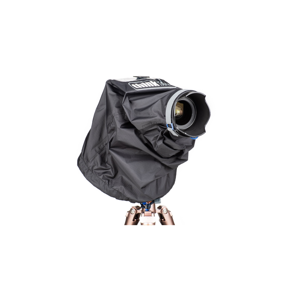 A black camera cover shields a camera mounted on a tripod.