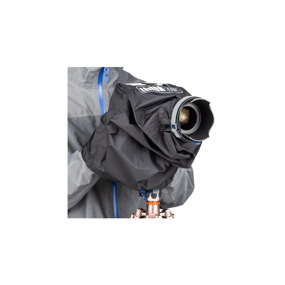 A person holding a camera under a black rain cover on a tripod.