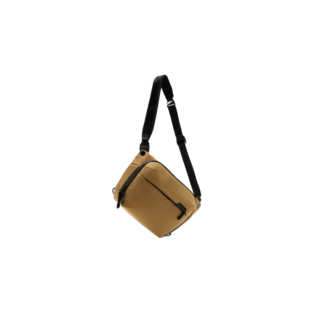 Een bruine crossbody tas met zwarte riem hangt.