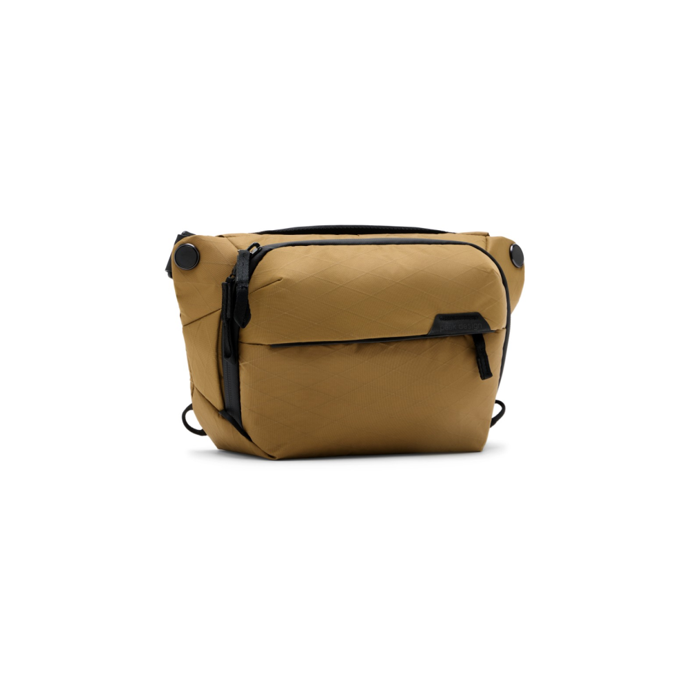 Een bruine crossbody tas met zwarte accenten en ruitvormige stof.