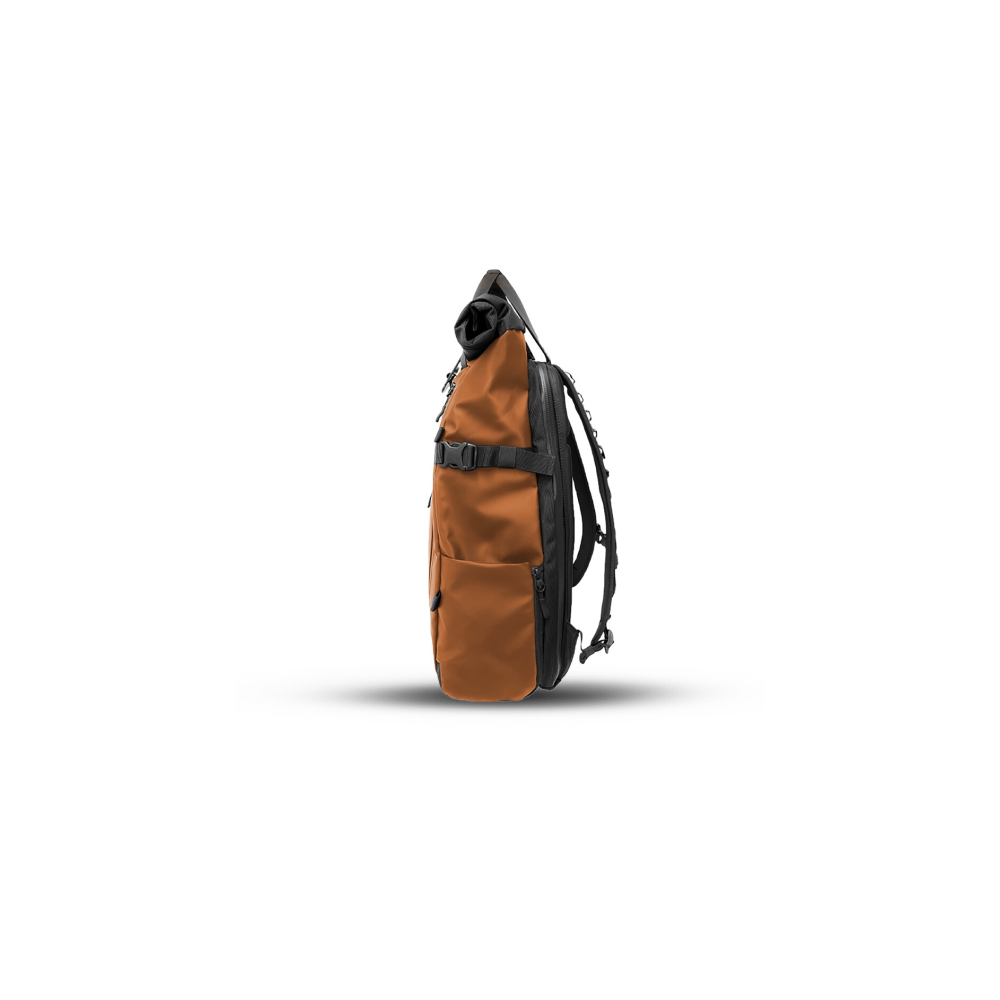 Een oranje rugzak met zwarte banden en ritsen, van de zijkant gezien.