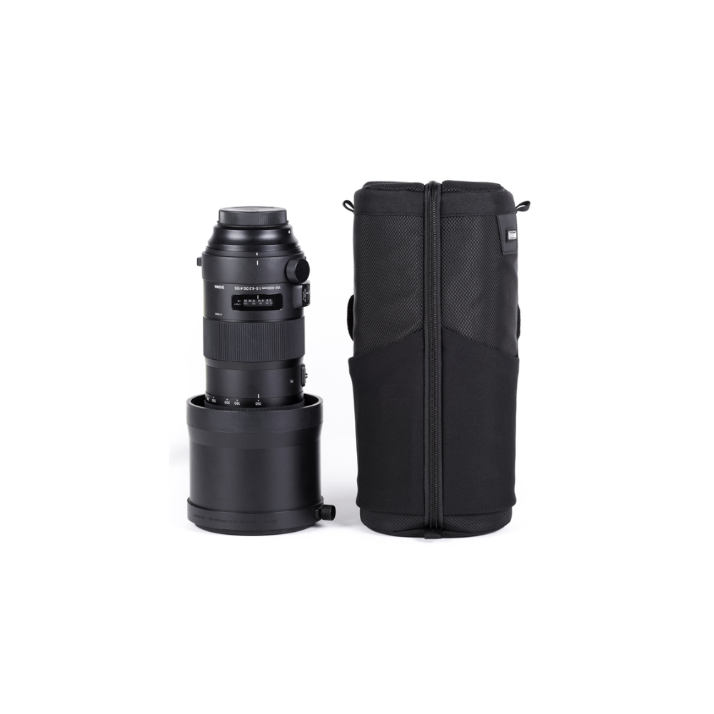 A black camera lens and its matching case stand side-by-side on a white background.
