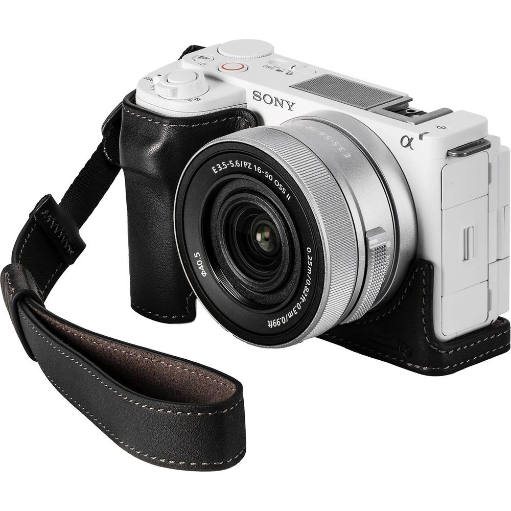 White Sony camera with a black leather case and strap.