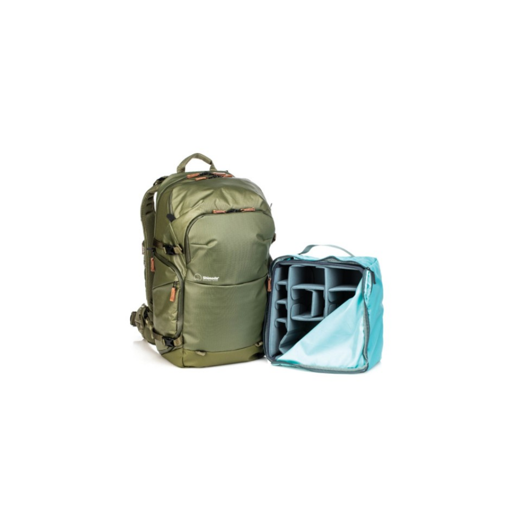 A green backpack stands next to an open teal bag with compartments.