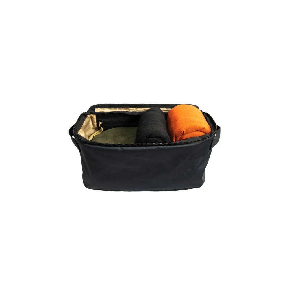 Black bag with green, black, and orange fabrics inside.