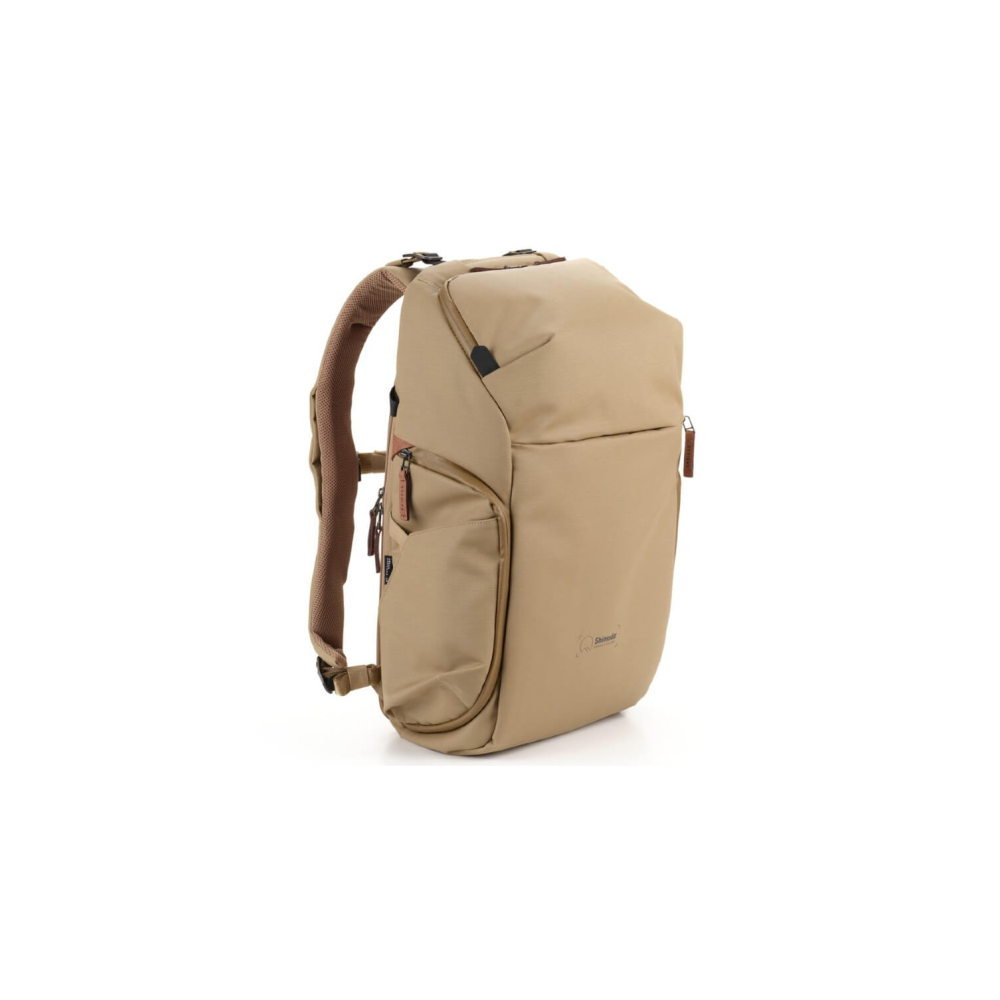 A beige backpack with brown straps stands against a white background.