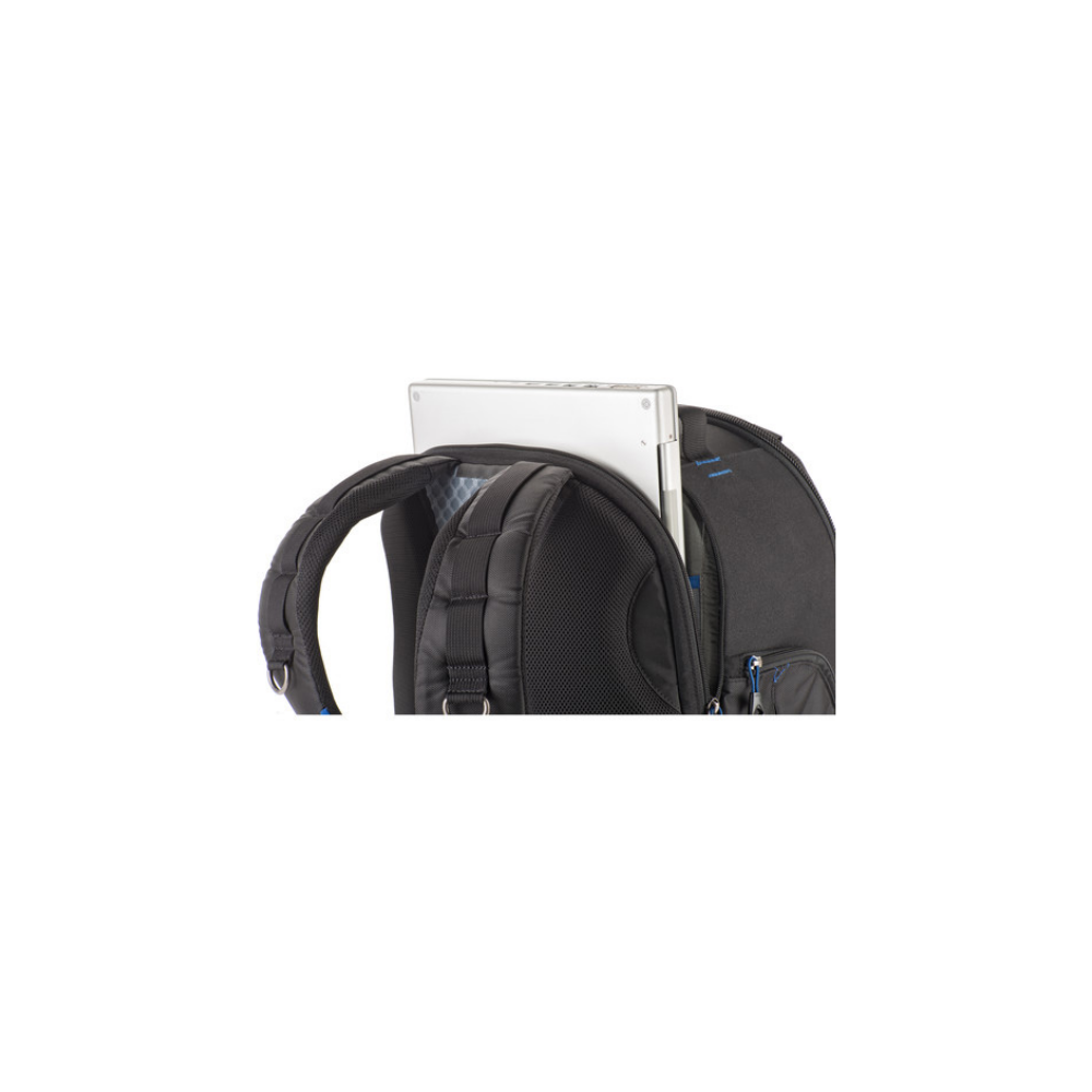 A silver laptop is partially visible, sticking out of the top compartment of a black backpack against a white background.