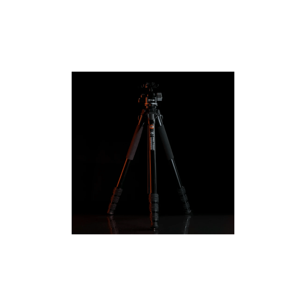 A black tripod with three legs stands on a glossy surface.