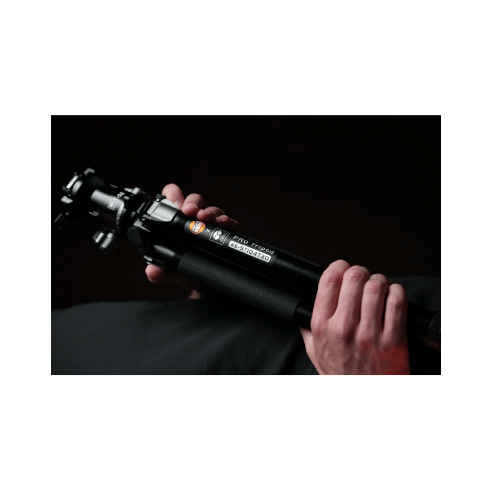 Hands hold a black tripod labeled "PRO Tripod KE-ST104T30".
