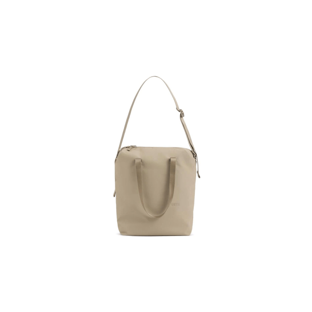Een beige tote tas met twee hengsels en een lange riem, op een witte achtergrond.