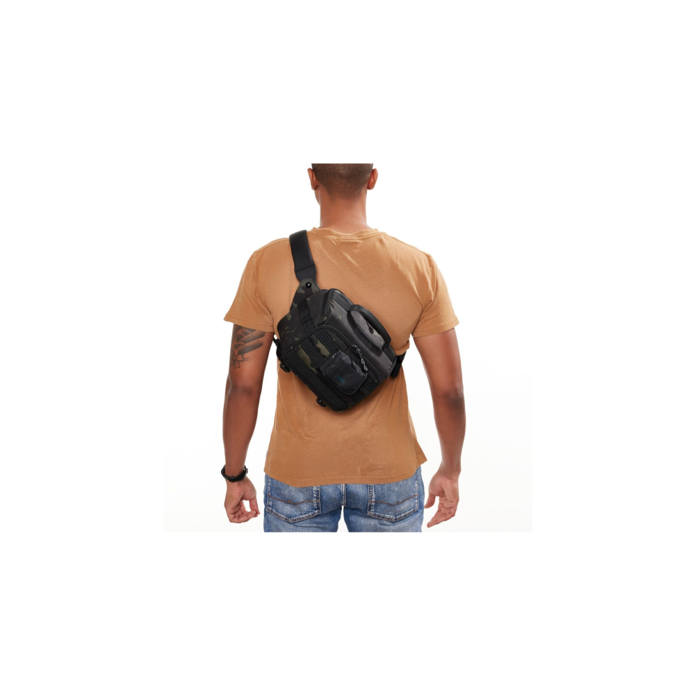Man wearing a camo sling bag, brown t-shirt, and blue jeans.
