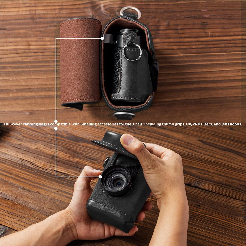 Zwarte leren cameratashoes met bruin inzetstuk op houten tafel.