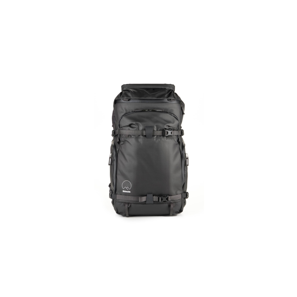 A black backpack with buckles and straps stands against a white background.
