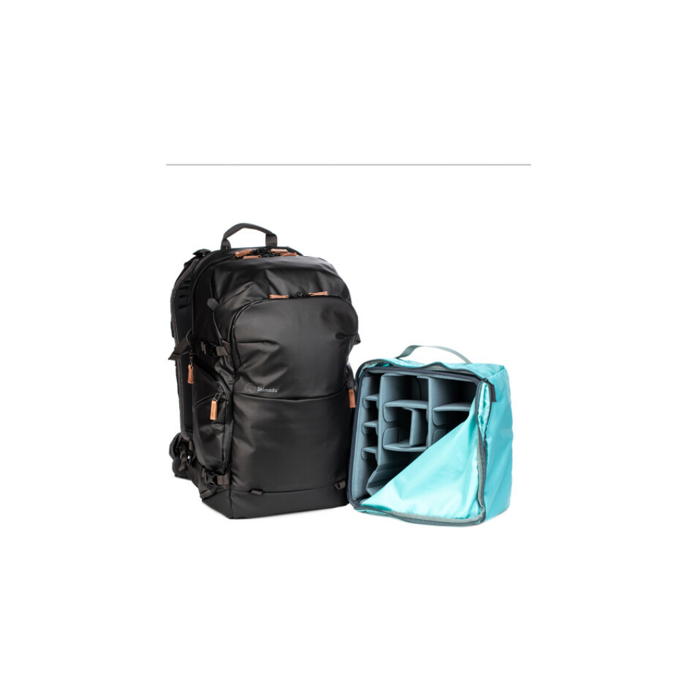 A black backpack next to an open blue camera insert with compartments.